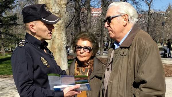 Policía con dos ancianos Policía con dos ancianos