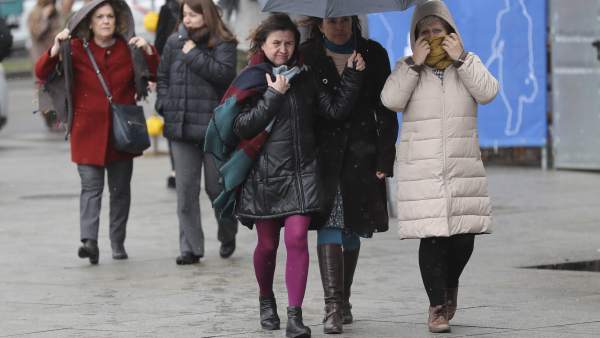 Varias personas se protegen del frío y la nieve en Madrid. Varias personas se protegen del frío y la nieve en Madrid.