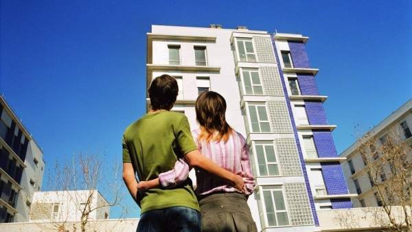 Una pareja ante un edificio de pisos Una pareja ante un edificio de pisos