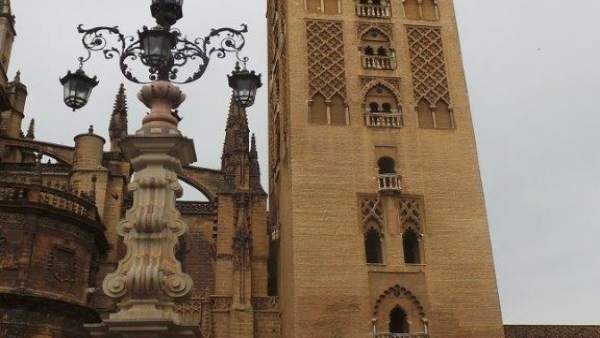 Triciclo de Correos ante la Giralda de Sevilla Triciclo de Correos ante la Giralda de Sevilla
