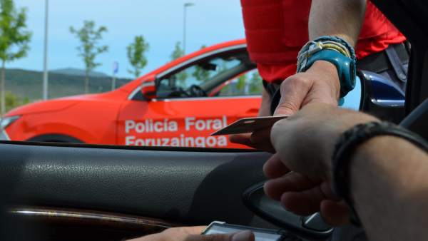 Un conductor entrega su documentación a un policía foral Un conductor entrega su documentación a un policía foral