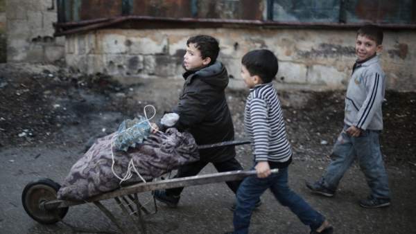 Niños empujan un carro en Ghuta Oriental, cerca de Damasco Niños empujan un carro en Ghuta Oriental, cerca de Damasco