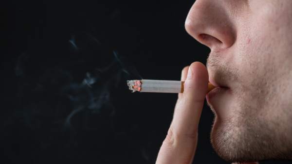 Un hombre dando una calada al cigarro. Un hombre dando una calada al cigarro.