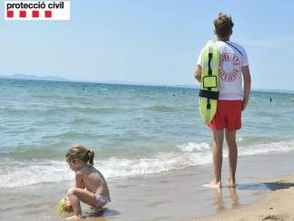 Un socorrista vigila el baño en una playa catalana