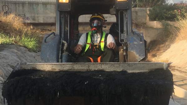 Técnico cargando toallitas del Colector Norte con una excavadora Técnico cargando toallitas del Colector Norte con una excavadora
