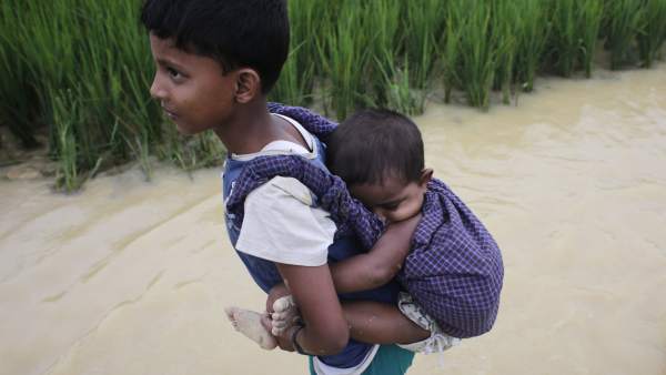 Un niño rohinyá portea a su hermana pequeña cruzando de Birmania a Bangladesh Un niño rohinyá portea a su hermana pequeña cruzando de Birmania a Bangladesh