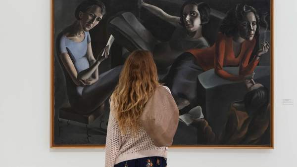 Una espectadora contempla 'La tertulia' de Ángeles Santos Una espectadora contempla 'La tertulia' de Ángeles Santos