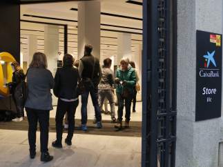 Cola para retirar efectivo antes de la apertura de la oficina de La Caixa de Vic.
