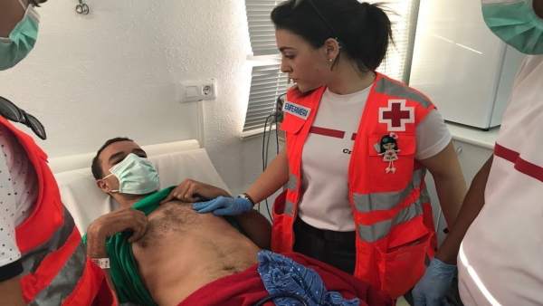 Cruz Roja atendiendo a uno de los inmigrantes Cruz Roja atendiendo a uno de los inmigrantes