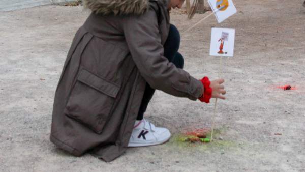 Una niña señalia excrementos de perro Una niña señalia excrementos de perro