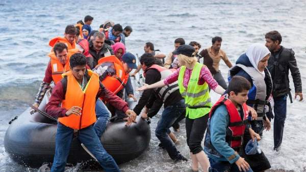Migrantes llegando en una barca hinchable Migrantes llegando en una barca hinchable
