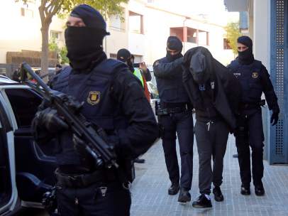 Los Mossos d'Esquadra escoltan a uno de los detenidos durante una operación contra el terrorismo yihadista en Sant Pere de Ribes en la que se han realizado registros a varias viviendas y se han detenido, al menos, a dos personas.