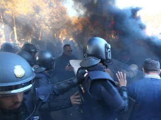 Policías marchan entre el humo de las bengalas