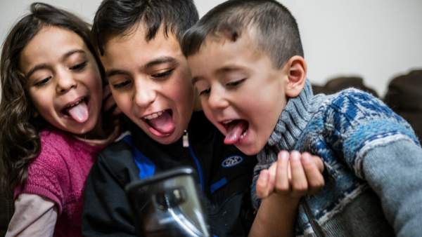 Niños jugando con un móvil Niños jugando con un móvil