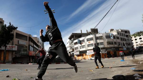 Varios hombres lanzan piedras a las tropas israelíes en Hebrón (Palestina). Varios hombres lanzan piedras a las tropas israelíes en Hebrón (Palestina).