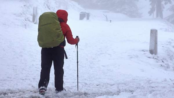 Un hombre pasea por la montaña nevada Un hombre pasea por la montaña nevada