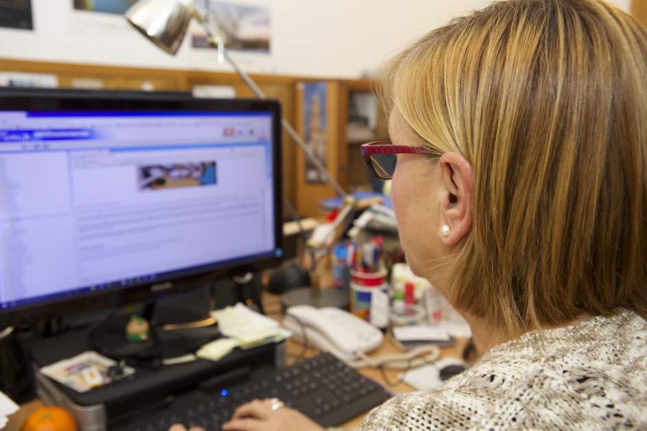 Algunas posibles cusas del dolor de cabeza Una mujer trabajando frente al ordenador.