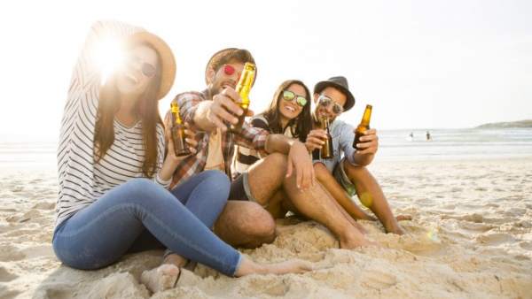 Jóvenes bebiendo en una playa Jóvenes bebiendo en una playa