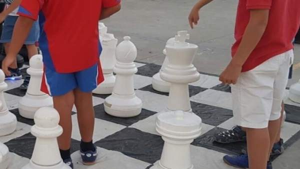 Unos niños juegan con un ajedrez gigante Unos niños juegan con un ajedrez gigante