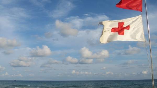 Una bandera de Cruz Roja ondea al viento Una bandera de Cruz Roja ondea al viento