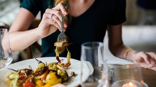 Un cliente degustando un plato en un restaurante. Un cliente degustando un plato en un restaurante.