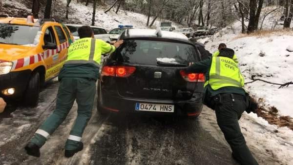 Dos agentes ayudan a un coche a proseguir su marcha en el Puerto de las Palomas. Dos agentes ayudan a un coche a proseguir su marcha en el Puerto de las Palomas.