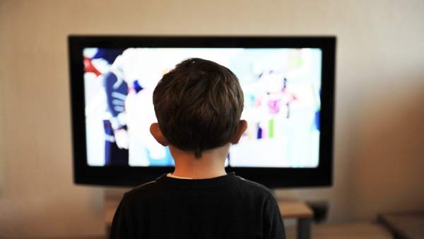 Un niño delante del televisor Un niño delante del televisor