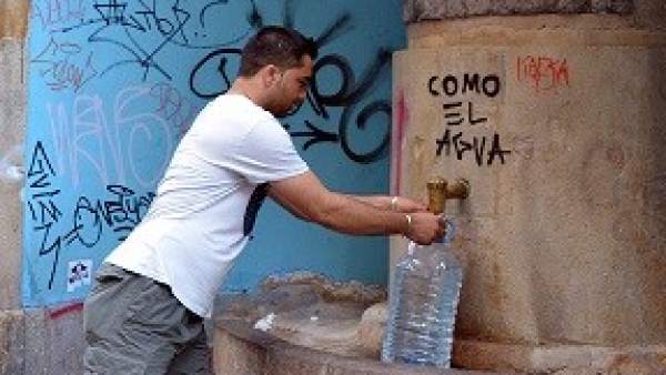 Hombre cogiendo agua. Hombre cogiendo agua.