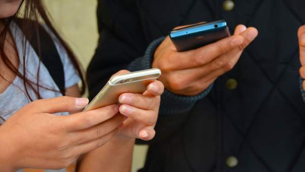 Chateando. Gente con el móvi. Usando el móvil. Jóvenes con smartphone Chateando. Gente con el móvi. Usando el móvil. Jóvenes con smartphone