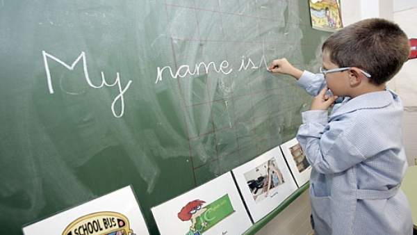 Niño escribe inglés en la pizarra del colegio Niño escribe inglés en la pizarra del colegio