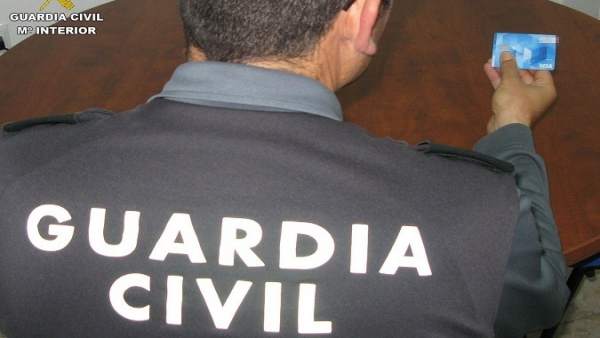 Agente de la Guardia Civil con una tarjeta de crédito Agente de la Guardia Civil con una tarjeta de crédito