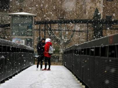 Dos jóvenes debajo de la nieve en el puente de Tordera.