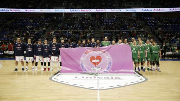 Jugadores del Unicaja con la bandera de No a la violencia machista Jugadores del Unicaja con la bandera de No a la violencia machista