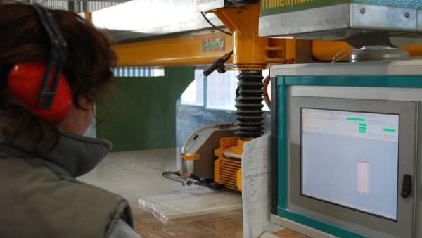 Un operario maneja una máquina de control numérico Un operario maneja una máquina de control numérico