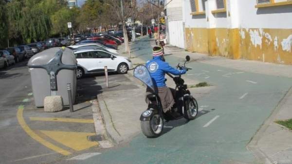 Moto eléctrica circulando por un carril-bici de Sevilla Moto eléctrica circulando por un carril-bici de Sevilla