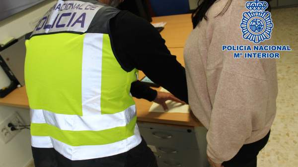 Un agente toma las huellas a una detenida Un agente toma las huellas a una detenida