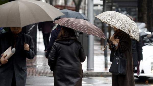 Persona con paraguas por la lluvia Persona con paraguas por la lluvia