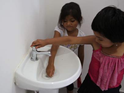 Dos niñas juegan en los baños del colegio de la comunidad Huaytu de Buena Vista