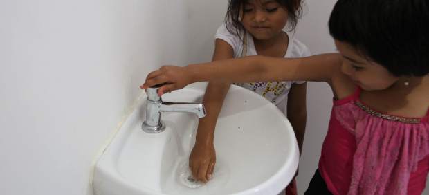 Dos niñas juegan en los baños del colegio de la comunidad Huaytu de Buena Vista