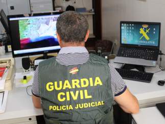 Un agente de la Guardia Civil inspecciona archivos en un ordenador