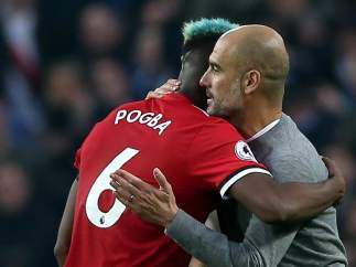 Pogba y Guardiola hablan sobre el césped del Etihad Stadium.