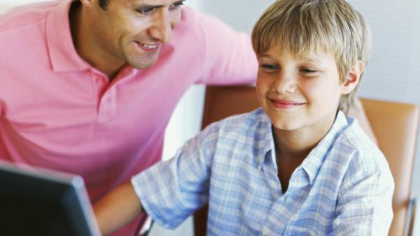 Un padre y su hijo con un ordenador en casa Un padre y su hijo con un ordenador en casa