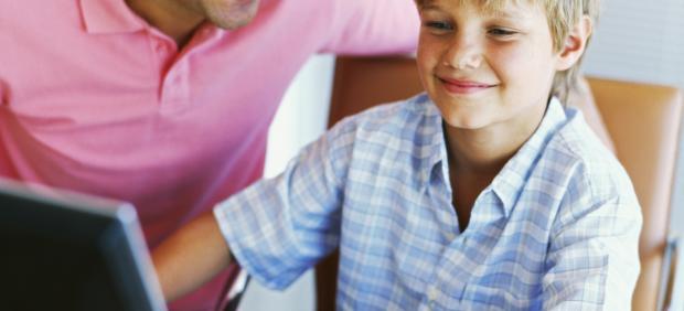 Un padre y su hijo con un ordenador en casa