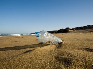 Botella de plástico en la arena de la playa