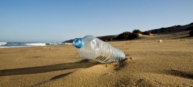 Botella de plástico en la arena de la playa