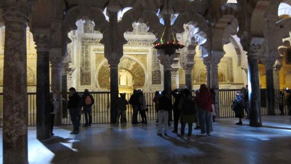Turistas ante el Mihrab de la Mezquita, del que les separa una valla Turistas ante el Mihrab de la Mezquita, del que les separa una valla