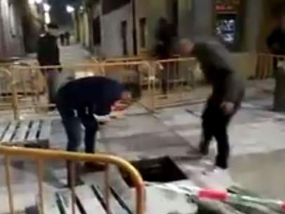 Dos amigos, preocupados porque otro se ha caído dentro de una alcantarilla.
