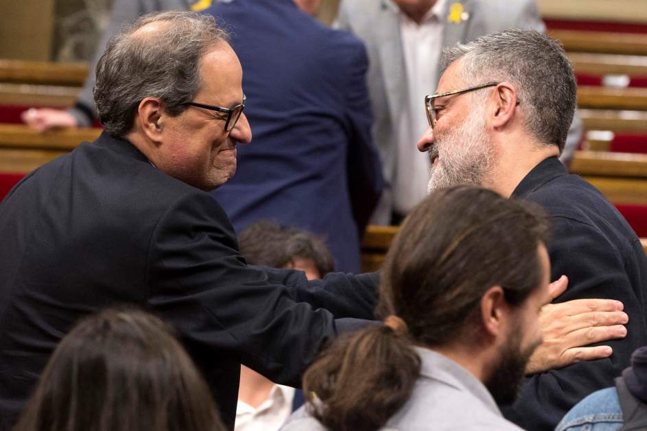 Torra y el portavoz de la CUP, Carles Riera, se saludan en el Parlament.