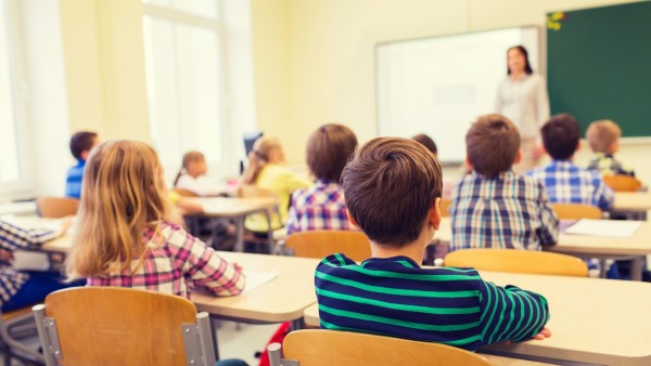 Alumnos atienen a una profesora en un centro educativo Alumnos atienen a una profesora en un centro educativo