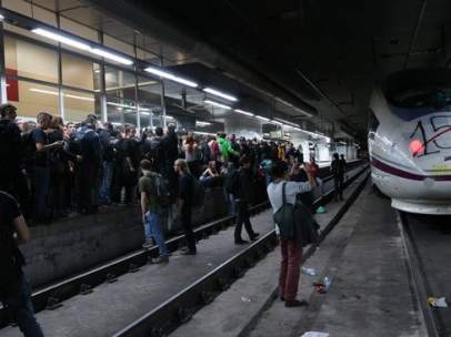 Varias personas acupan la andén de la estación de Sants de Barcelona.